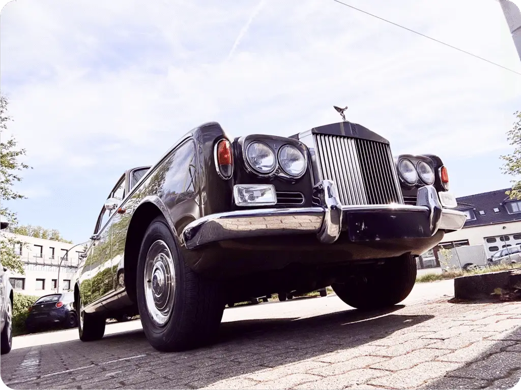 Luxusauto Rolls-Royce in Schwarz, aus der Froschperspektive von vorne fotografiert bei sonnigem Wetter