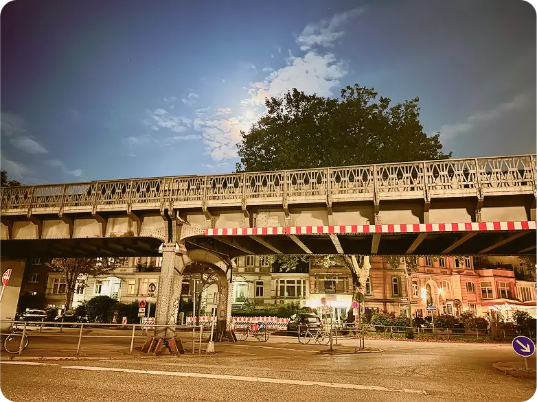 Abendaufnahme einer Brücke in Hamburg mit städtischer Umgebung im Hintergrund