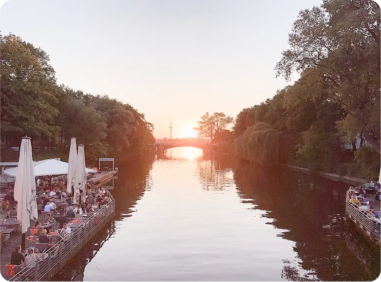 Elbe bei Sonnenuntergang mit Brücke in der Ferne und Restaurant am linken Ufer